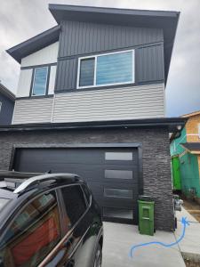 een auto geparkeerd voor een huis met een garage bij Home Away from Home 2 bedrooms in Edmonton