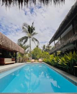 a swimming pool in front of a house with a palm tree at Terra Siargao in General Luna +13 photos