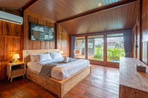 a bedroom with a bed and a large window at De Sirame Villa in Ubud +30 photos