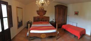 een slaapkamer met een bed met een rode sprei bij Can Beliu in Roda del Ter