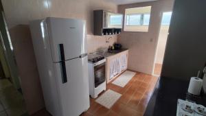 a kitchen with a white refrigerator and a stove at Aptos em Duas Barras - RJ in Duas Barras