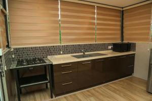 a kitchen with wooden cabinets and a sink at Mount Star Villa in Sita Eliya
