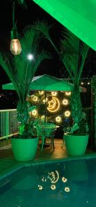 a pool with palm trees and a table and lights at Hotel Pousada Irmaos Freyhardt in Rio de Janeiro