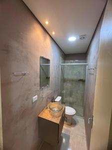 a bathroom with a sink and a toilet and a shower at Hotel Ideal in Inocência