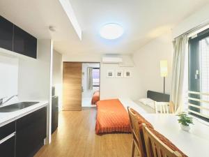 a room with a kitchen and a bedroom with a bed at ToyoHomes西新宿 in Tokyo