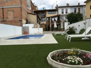 un patio trasero con piscina y un jardín con flores en Can Beliu, en Roda de Ter