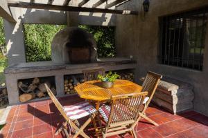 a patio with a table and chairs and an oven at La Tapera Casa de campo in Los Sauces
