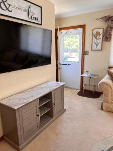 a living room with a large flat screen tv at Bayshore Breeze Hampton-Buckroe Long Term Stay in Hampton