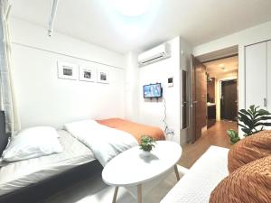 a bedroom with a bed and a table and a couch at ToyoHomes西新宿 in Tokyo