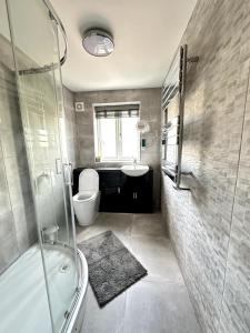 ein Badezimmer mit Dusche, Toilette und Waschbecken in der Unterkunft Modern Ground floor 2 Bed Room Apartment Work Leisure Free Parking in Woking