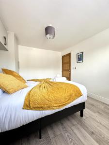 ein Schlafzimmer mit einem Bett mit einer gelben Decke darauf in der Unterkunft Modern Ground floor 2 Bed Room Apartment Work Leisure Free Parking in Woking + 13 Fotos