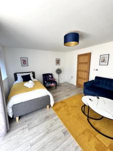 ein Schlafzimmer mit einem Bett und einer blauen Couch in der Unterkunft Modern Ground floor 2 Bed Room Apartment Work Leisure Free Parking in Woking