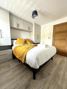 een slaapkamer met een groot bed met gele kussens bij Modern Ground floor 2 Bed Room Apartment Work Leisure Free Parking in Woking +16 foto's