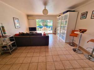 - un salon avec un canapé et du carrelage dans l'établissement Appartement avec grande terrasse, piscine chauffée et parking, à 700m des plages de Collioure - FR-1-309-402, à Collioure