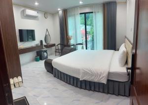 a bedroom with a bed and a desk and a television at Dũng Thảo Hostel in Bắc Hà