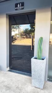 a cactus in a pot sitting in front of a door at Studio 61- No Coração de Curvelo in Curvelo