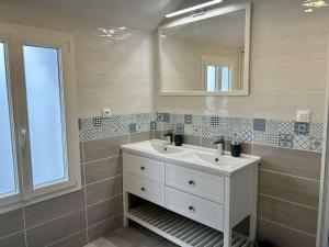 a bathroom with a white sink and a mirror at Villa Michel rénovée à Royan, proche plages - FR-1-494-215 in Royan +5 photos