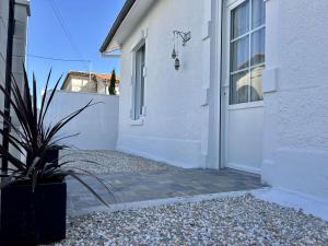 a white door of a white house with a potted plant at Villa Michel rénovée à Royan, proche plages - FR-1-494-215 in Royan