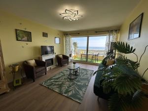 a living room with a couch and a television and a table at Appartement rénové 2 pièces avec WiFi en bord de mer - FR-1-224C-356 in Saint-Hilaire-de-Riez