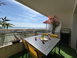 a table on a balcony with a view of the beach at Appartement rénové 2 pièces avec WiFi en bord de mer - FR-1-224C-356 in Saint-Hilaire-de-Riez +12 photos