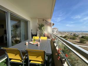 a table and chairs on a balcony with a view of the ocean at Appartement rénové 2 pièces avec WiFi en bord de mer - FR-1-224C-356 in Saint-Hilaire-de-Riez