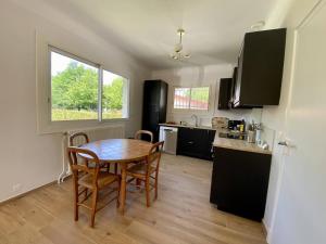 eine Küche mit Tisch und Stühlen in einem Zimmer in der Unterkunft Maison rénovée à Cambo, 2 ch, jardin, parking, WiFi - FR-1-495-154 in Cambo-les-Bains