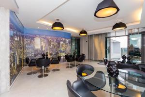 Una sala de reuniones con sillas y mesas negras en un edificio. en Studio Moderno no Centro com Piscina, Vista Panorâmica e Garagem, en Curitiba 122 fotos más
