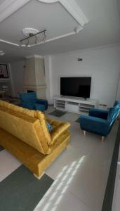 a living room with a couch and two chairs and a television at Casa Elegante Familiar hasta para 20 personas in Zipaquirá