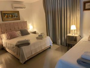 a bedroom with two beds with towels on the bed at La Malena, Casa Hotel in Valledupar