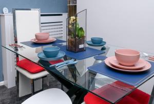 a glass table with plates and bowls on it at The Whitehouse M6, Junction 10 With Parking in Walsall