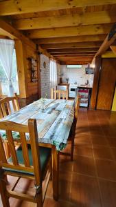 una gran mesa de madera en una habitación con cocina en Cabaña Los Leños, en Lago Puelo
