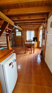 Una cocina con un refrigerador blanco y una mesa. en Cabaña Los Leños, en Lago Puelo 9 fotos más