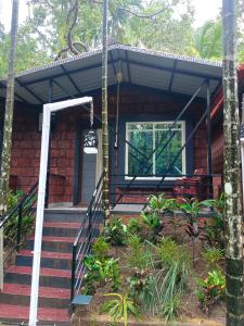 a brick house with stairs leading to the front door at Dandeli palm tree cottages in Dandeli +6 photos