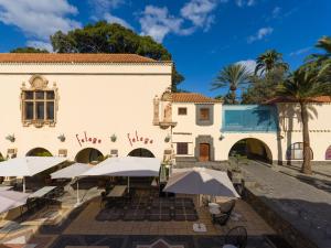 a building with tables and umbrellas in front of it at Apartment in Las Palmas near Playa Alcaravaneras in Las Palmas de Gran Canaria