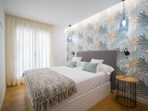 a bedroom with a large bed with a floral wallpaper at Apartment in Las Palmas near Playa Alcaravaneras in Las Palmas de Gran Canaria