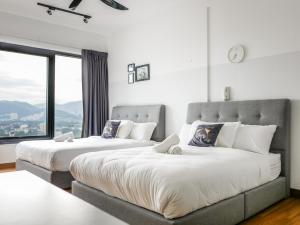 zwei Betten in einem Zimmer mit großem Fenster in der Unterkunft Casita 22, 218 Macalister Georgetown City & Seaview in George Town