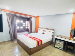a bedroom with a bed and a television in it at Đức Trâm Hotel Hồ Chí Minh in Ho Chi Minh City +1 photo