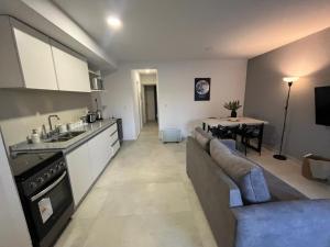 a kitchen and living room with a couch and a table at Andes Nomad Mendoza in Godoy Cruz