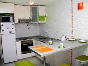 una pequeña cocina con electrodomésticos verdes y blancos en Albatros, en Los Cristianos