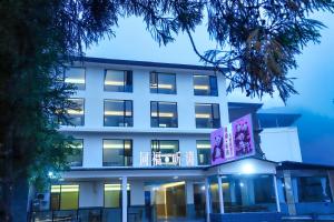 un edificio bianco con un cartello davanti di Wolong Tongfu Tingtao B&B, China Great Beauty Bear Store a Wolongguan