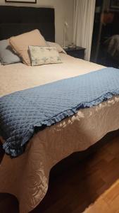 un letto con una coperta blu e un cuscino di Departamento frente al mar en concon reñaca a Concón