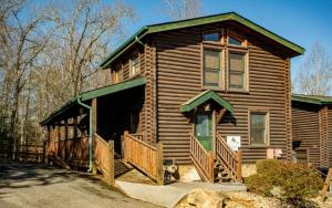 a log cabin with a front porch and a balcony at Queens Log Cabin in Gatlinburg