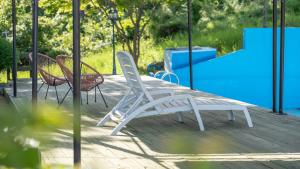 Dos sillas y una mesa en una terraza. en Seokmodo supsokbadapunggyeong pension, en Incheon