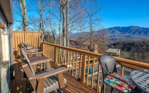 a deck with two chairs and a table with mountains in the background at Majestic Getaway 1427 in Gatlinburg