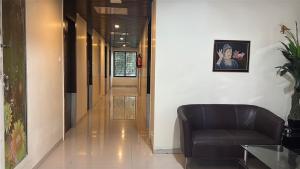 a hallway with a leather chair and a hallway with a corridorngthngthngthngth at Hotel Lotus Grand Jubilee in Hyderabad +1 photo