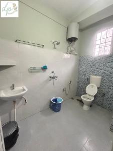 a bathroom with a toilet and a sink at DP Homestay Itanagar in Itānagar