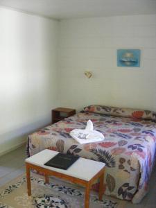 a bedroom with a bed and a table with a book on it at Central Motel in Rarotonga