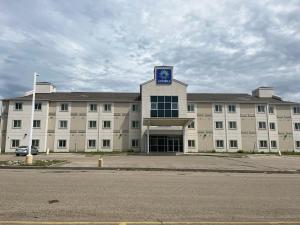 a large white building with a clock on top of it at Aurora Inn Estevan in Estevan