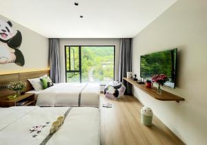 una camera da letto con due letti e una grande finestra di Wolong Tongfu Tingtao B&B, China Great Beauty Bear Store a Wolongguan