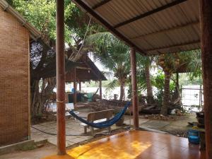 Giồng Tú ÐiềnBenTrestay的房屋内带吊床的门廊